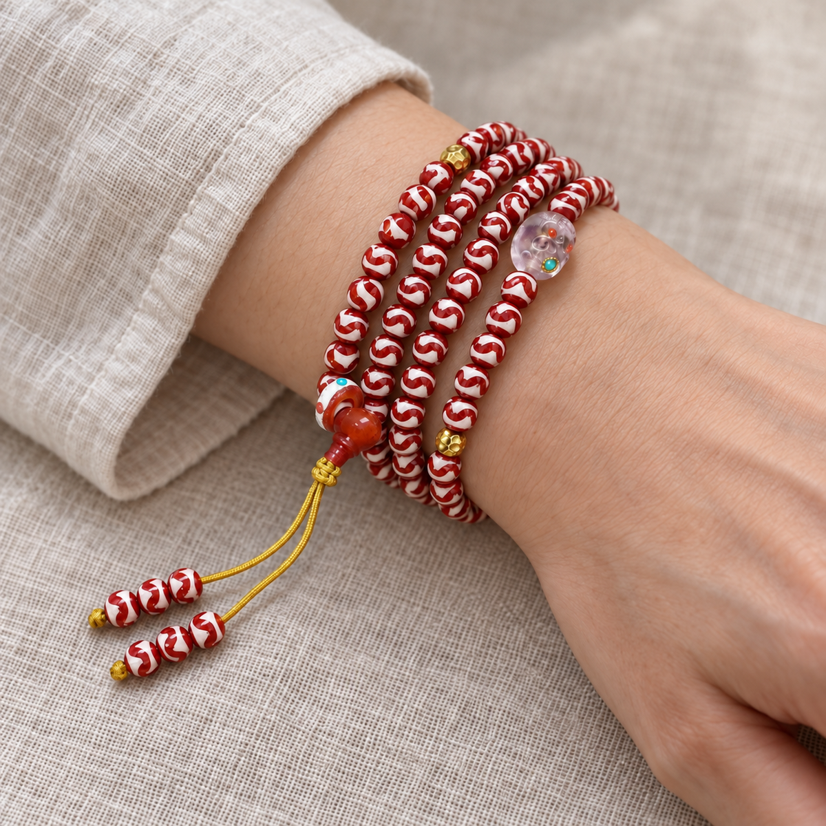 Tiger-Tooth Dzi and Amethyst Mala — wrist resting