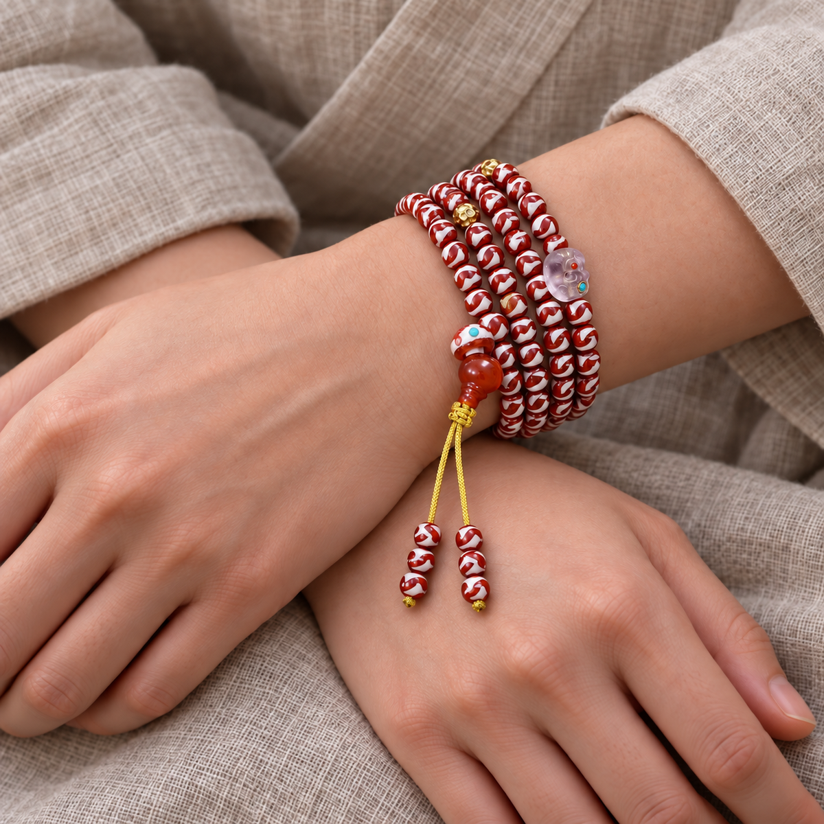 Tiger-Tooth Dzi and Amethyst Mala — wrist crossed