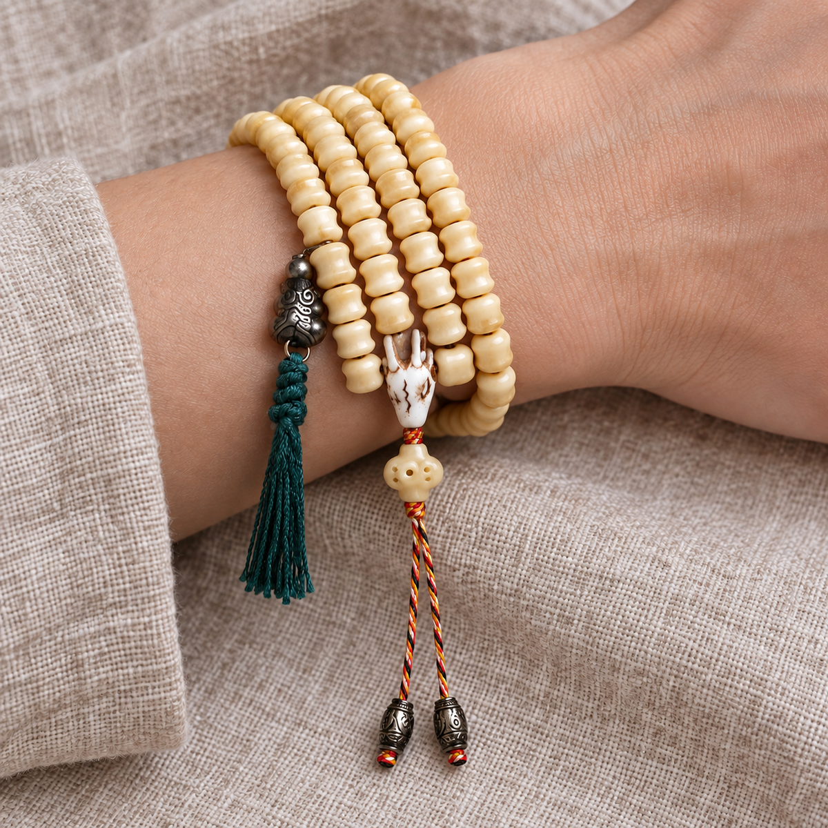 EverestArtstudios Carved Bone 108-Bead Mala with Decorative Metal Charms — wrist resting