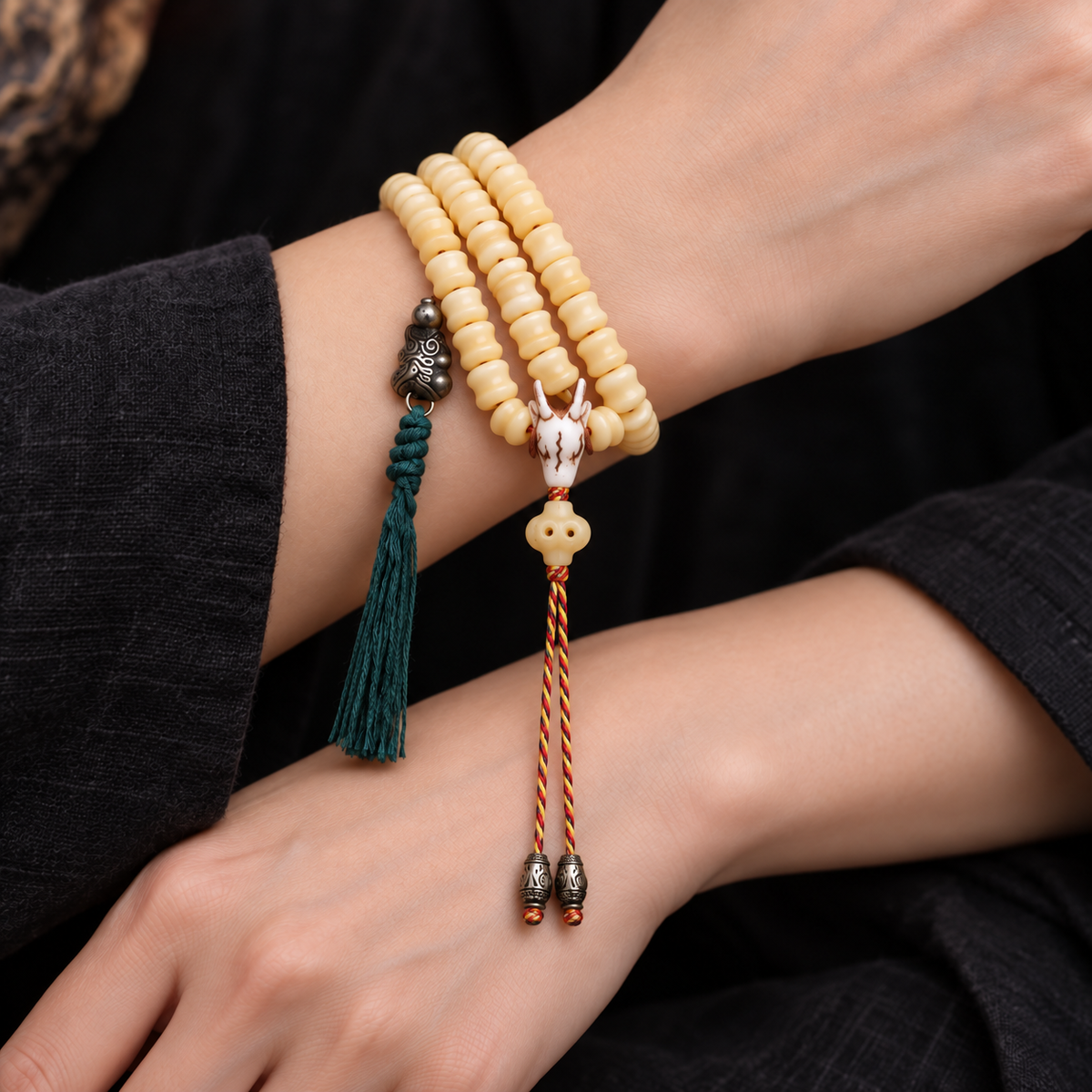 EverestArtstudios Carved Bone 108-Bead Mala with Decorative Metal Charms — wrist crossed