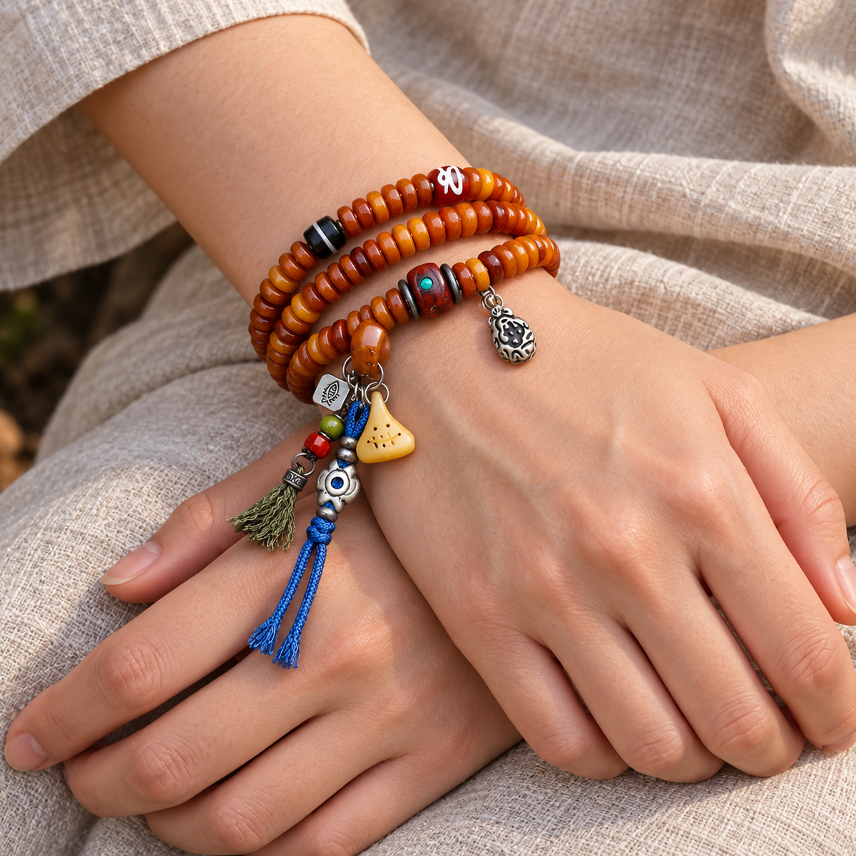 Yak bone mala with Phoenix Eye Bodhi accents — wrist crossed