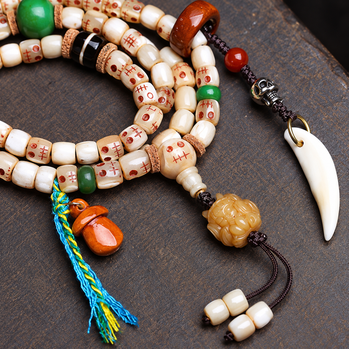 EverestArtstudios Carved Fish Bone 108-Bead Mala with Colorful Accents and Curved Pendant — connection detail