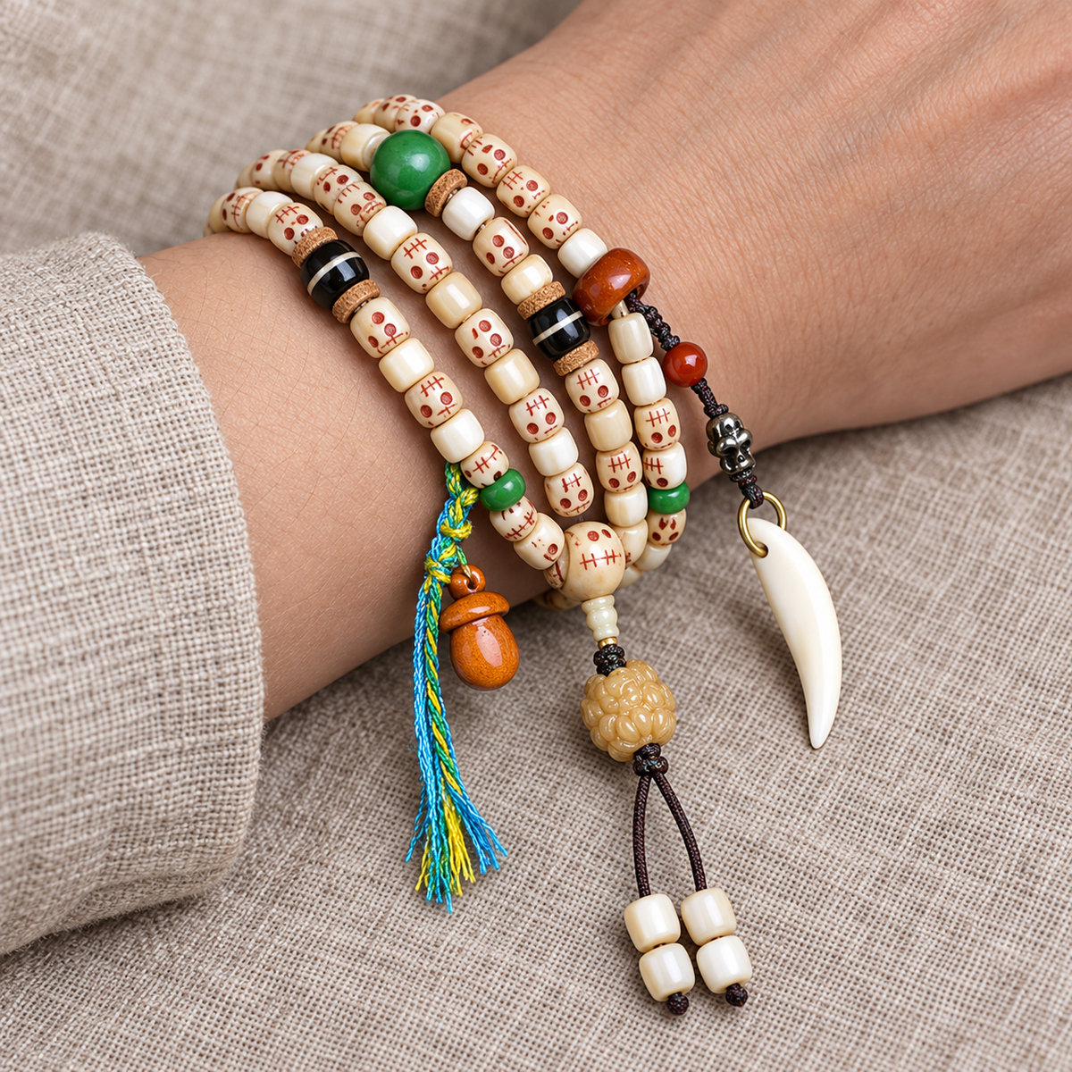 EverestArtstudios Carved Fish Bone 108-Bead Mala with Colorful Accents and Curved Pendant — wrist resting